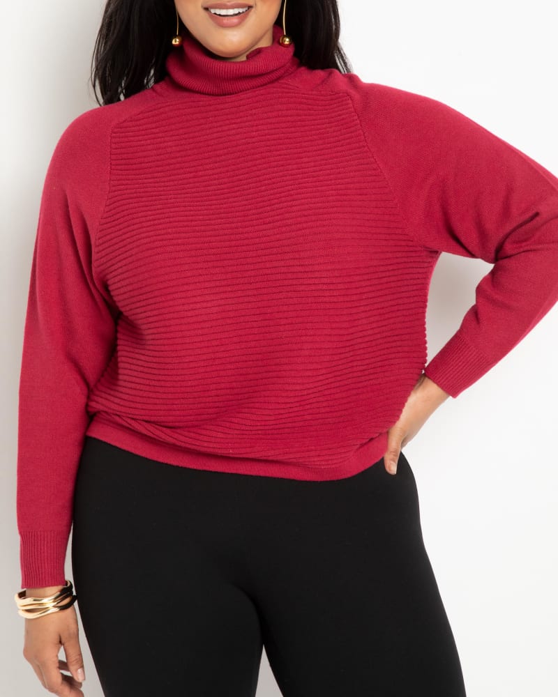 Front of a model wearing a size 14/16 Cosima Relaxed Turtleneck in Biking Red by ELOQUII. | dia_product_style_image_id:242064